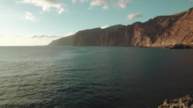 Tenerife 'deki Los Gigantes Kayalıkları' nın okyanus manzaralı kayalık arazisinde arka planda yükselen volkanik kayalar var...