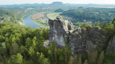 Kayalık oluşumları ve arka planda dolambaçlı bir nehri barındıran manzaralı orman manzarası..