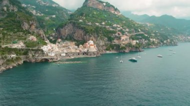 Amalfi Sahili 'nin büyüleyici bir kıyı kasabası olan Atrani' nin manzarası sakin mavi denize dağılmış tekneleri arka planda yemyeşil tepeler...