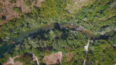 Hırvatistan 'da yaz güneşli bir günde yeşil ormanlarla çevrili bir dağ nehri manzarası.