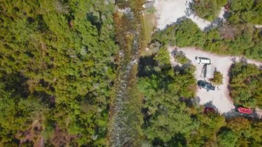 Hırvatistan 'da arabaları ve insanları olan bir toplanma yerinin yakınındaki Cetina Nehri' nde sallar.