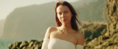 Huzurlu bir kadın arka planda dağlarla kameraya bakar, ılık ışıkla yıkanır. Tenerife Kanarya Adaları İspanya..