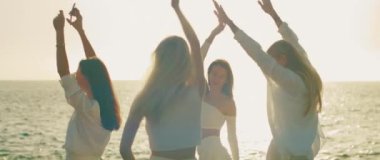 Dans ederken kollarını aynı anda kaldıran ve okyanusun kıyısında güneş gibi parlayan, suya yansıyan kadınlar...