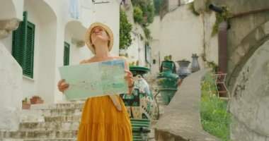 Haritalı bir kadın yaz boyunca İtalyan sahil kasabası Atrani 'de merdivenlere bakar..