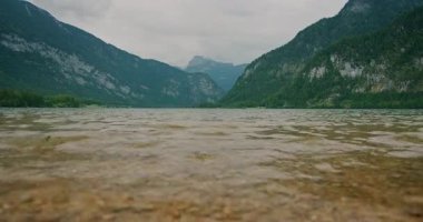 Arka planda kayalık bir kıyısı ve sisli dağları olan Gosausee dağının alçak açılı görüntüsü..