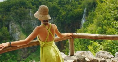 Plitvice Gölü Hırvatistan 'daki ahşap gözcülerden uzak şelalelere hayran olan kadın.
