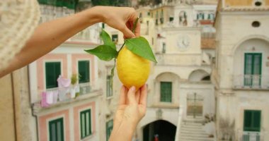 Atrani şehrinin arka planında renkli evler olan limonların kapatılması.