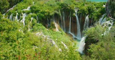 Plitvice Gölleri Hırvatistan 'daki yemyeşil uçurumlardan çağlayan şelalelerin çarpıcı manzarası.