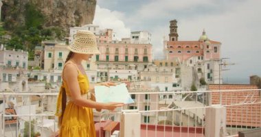 Çatıda haritası olan turist Amalfi kıyısındaki Akdeniz kenti Atrani 'ye bakıyor.