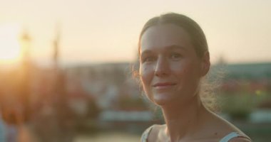 Çek Cumhuriyeti Prag 'da gün batımında Charles Köprüsü' nde gülümseyen bir kadın..