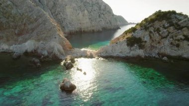 Günbatımında Kefalonia adasında turkuaz deniz ve dramatik uçurumlarla Rocky körfezi.