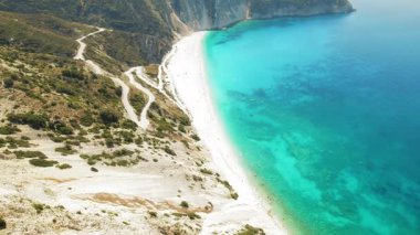 Kefalonya 'da beyaz kum ve turkuaz suyla Myrtos Sahili' nin yukarısında kıvrımlı bir yol..