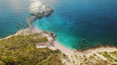 Beyaz kumlu sahili ve canlı turkuaz suyu olan gizli körfezin havadan görünüşü..