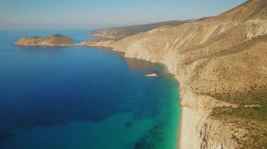 Yunanistan 'ın Kefalonya' daki engebeli uçurumlarda ve berrak sularda altın saat ışığı parlıyor.