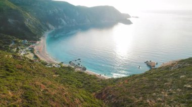 Güneş doğarken Kefalonia 'daki beyaz çakıl taşlı kumsal ve körfezin havadan görünüşü.