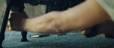 Nişancı hedefe nişan almadan önce çift ayaklı tüfeği ayarlıyor..