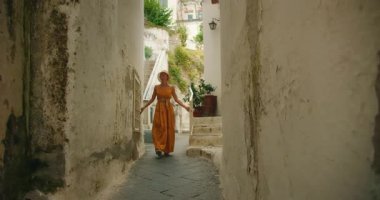Amalfi kıyısındaki bir İtalyan köyünde kadın dar bir sokakta yürüyor..
