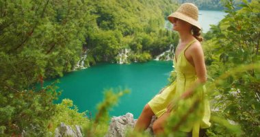 Plitvice turkuaz göllerini ve uzak şelaleleri seyreden bir kadın..