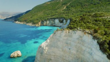 Yunanistan 'daki İyon Adası' nın kireçtaşı kayalıklarından çarpıcı kıyı manzarasının keyfini çıkaran iki kişi.
