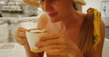 Gülümseyen kadın Atrani şehir merkezindeki sokak kafesinde cappuccino içiyor..