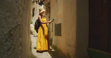 Yaz günü Atrani şehrinin dar bir sokağında harita okuyan bir kadın..