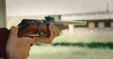 Atış menzilli hedeflere sürgülü tüfekle nişan alan kişi.