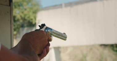 Erkek, ateşli silah eğitimi sırasında kadınlara silah kullanma konusunda talimat veriyor..