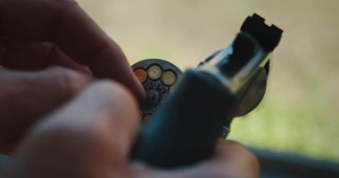 Atış menzilindeki silindirlere mühimmat yükleyen adamın elleri..