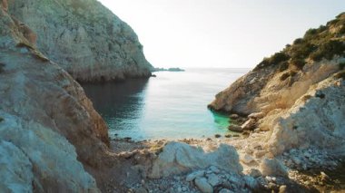 Yunanistan 'ın İyon adasında kayalık arazisi ve berrak deniz suyuyla huzurlu bir koy.