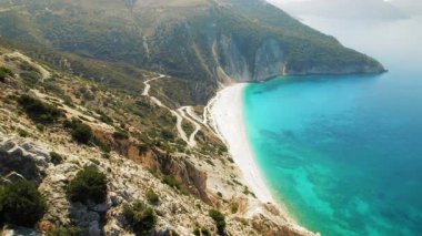 Sarp kayalıklar yazın uzak Kefalonia plajında el değmemiş turkuaz sularla buluşur..