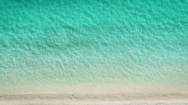 Yunanistan 'daki İyon adasında beyaz çakıl taşları üzerinde sakin sığ turkuaz kıyı şeridi.