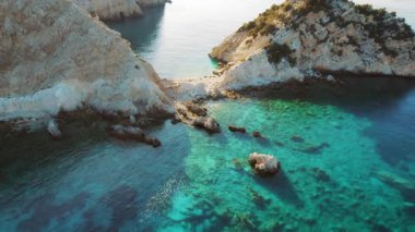 Yazın güneşli akşamlarda Kefalonia adasında turkuaz deniz sularıyla kayalık kıyı şeridi.