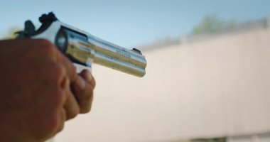 Tabanca tutan ve atış poligonuna yakın mesafeden ateş eden biri var..