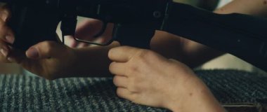 Tüfek eğitimi sırasında genç bir kadının düzgün tetik parmağı yerleştirmeyi öğrenmesi..