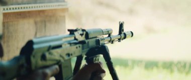 Tetikçi bipod 'a tüfek doğrultuyor ve atış talimi sırasında yoğun bir geri tepmeyle ateş ediyor..