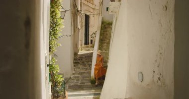 Güney İtalya 'da, Atrani şehrinde yaz günü dar bir sokakta yürüyen bir kadın..