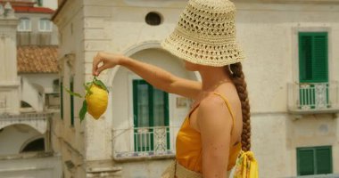 Bir yaz günü tarihi bir İtalyan sahil kasabası olan Atrani 'de bir limon tutan kadın..
