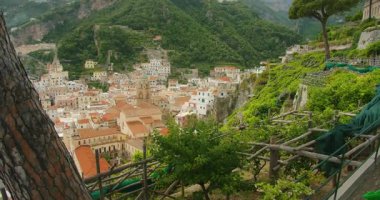 Amalfi şehri ve çevresindeki yeşil tepeler yaz günü bir patikadan görünüyor..