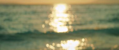 Yazın günbatımında güneş ışığı okyanus dalgalarında parıldıyor. Yumuşak odaklı lens etkisi..