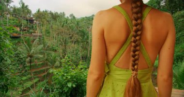 Bali 'de Tegallalang pirinç teraslarında gezen kadın manzaranın tadını çıkarıyor..