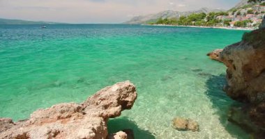Hırvatistan 'da yaz mevsiminde bir sahil kenti yakınlarında kayalık sahil ve yeşil mavi su.