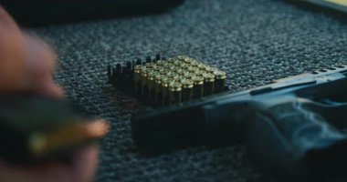 Atış taliminde bir kutu pirinç mermiyle dolu bir tabanca..