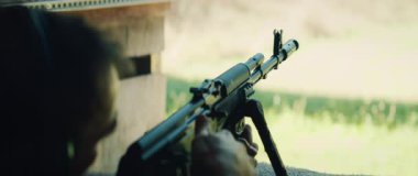 Tetikçi tüfeği hazırlarken namluya nişan alır ve dışarı ateş eder..