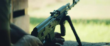 Tüfek hazırlayan adam, açık hava manzaralı, parlak doğal ortamda ateş etmeye hazır..