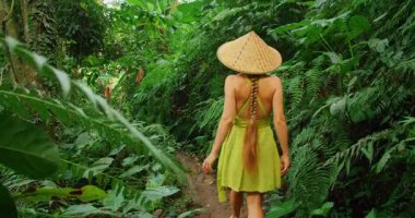 Yolculuk sırasında Tegallalang Bali 'de yoğun tropikal ormanda yürüyen bir kadın..