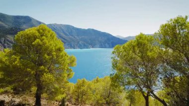 Yunanistan 'ın Kefalonia kentindeki uzak uçurumlar ve sakin sularla çam ormanları boyunca deniz manzarası.