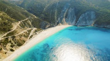 Turkuaz yaz denizi, Yunanistan 'ın Kefalonya kayalıklarında beyaz kumla karşılaştı.