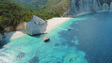 Kefalonya 'da turkuaz deniz bulunan beyaz kayalıklardan ve kumlu plajlardan geçen sürat teknesi Yunanistan' da.