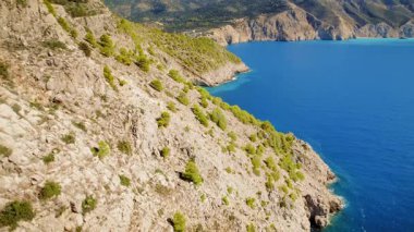 Açık yaz gününde engebeli kıyı şeridi ve turkuaz deniz manzarası geniş, Yunanistan.