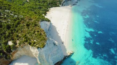 Yunanistan 'ın Kefalonia bölgesindeki yeşil ve turkuaz suları beyaz kayalıklarla dolu el değmemiş kıyı şeridi yemyeşil.